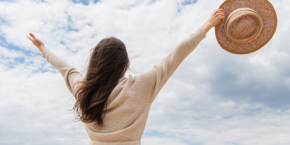 Frau die voller Selbstwertgefühl in die Lüfte streckt